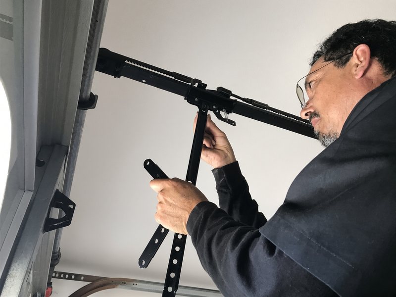 Alex adjusting a garage door opener arm and rail