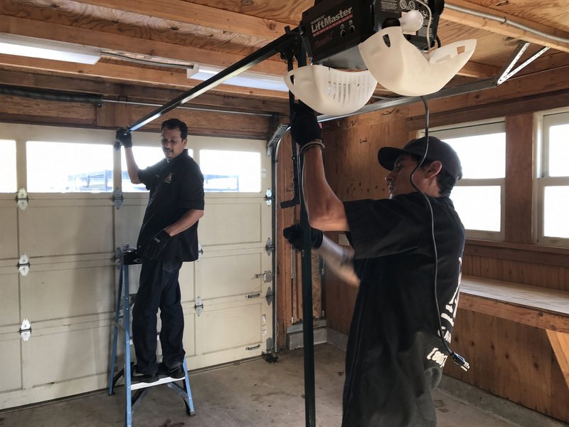 Alex and his son installing a garage door opener together