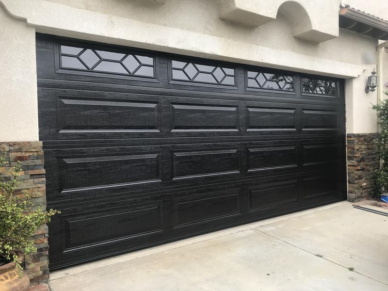 Black wood-grain raised-panel garage door with diamond-pattern windows