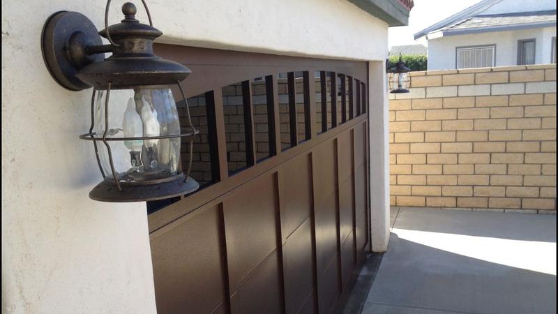 Dark brown carriage-style garage door with arched windows
