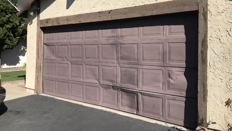 Garage door with bent and dented bottom panels