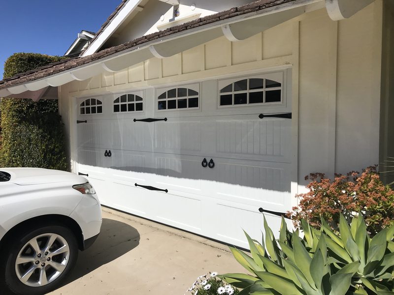 White carriage house, arched windows garage door installed by AA Garage Doors