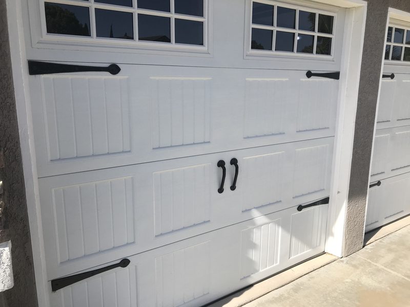 White carriage house, square windows, black hardware garage door installed by AA Garage Doors