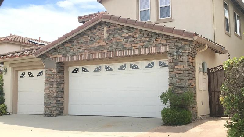White raised-panel garage doors with sunburst windows