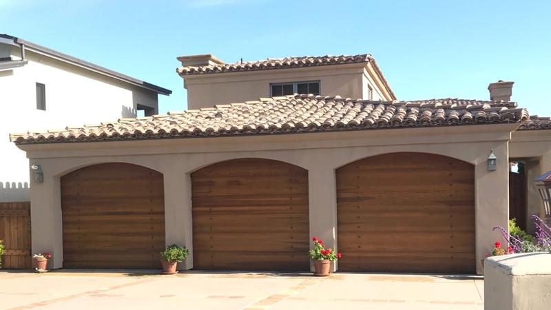 Three wood-look garage doors in arched openings