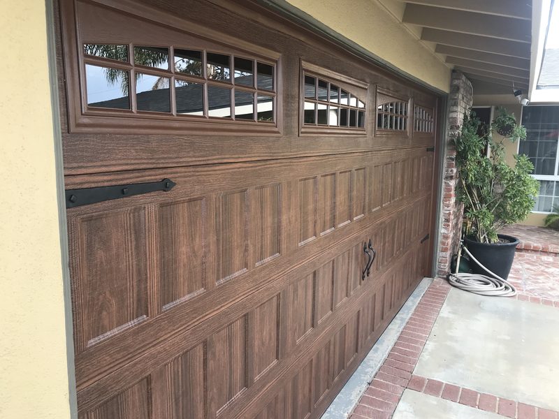 Wood-grain carriage with window tops garage door installed by AA Garage Doors