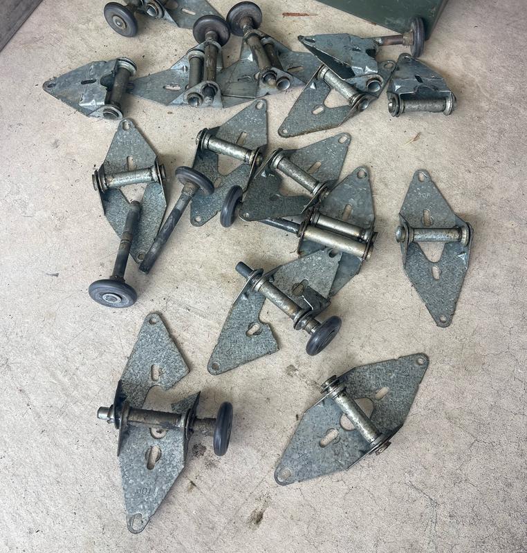 Pile of worn garage door rollers and hinges removed during a tune-up